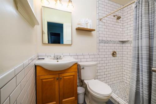a bathroom with a toilet and a sink and a mirror at Sea Gull Queen Suite in Cayucos