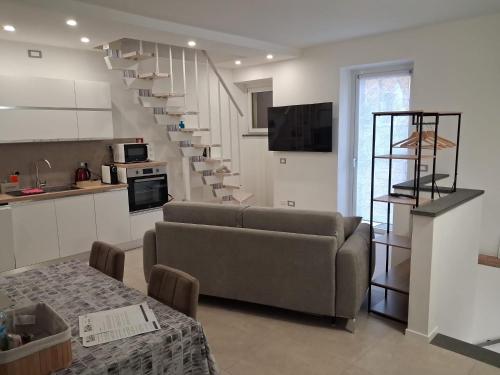 a living room with a couch and a spiral staircase at Il Borgo in Lurago D'Erba 
