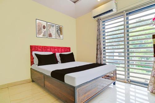 a bedroom with a bed and a large window at Hotel O Paradise Green in Indore