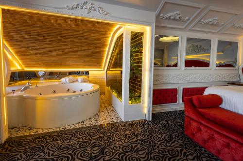 a hotel room with a tub and a bed at Andalouse Otel in Trabzon