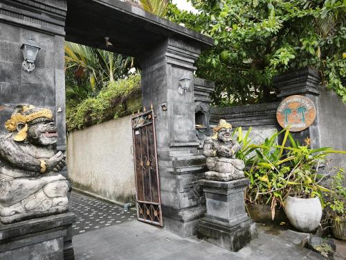 an entrance to a building with two statues at Sun Homestay Canggu in Canggu