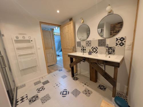 a bathroom with a sink and mirrors on the wall at Le Clos Macé - Maison d'hôtes proche BLOIS CHAMBORD in Saint-Denis-sur-Loire
