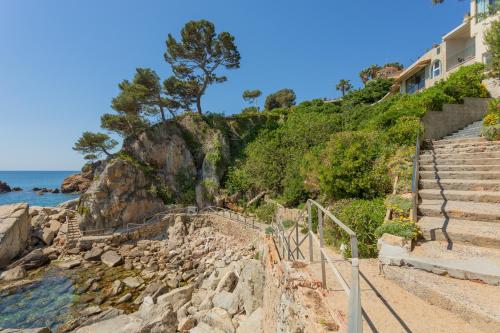 eine Treppe, die zum Strand hinunterführt in der Unterkunft Hotel Cap Roig & Spa by Brava Hoteles in Platja  d'Aro