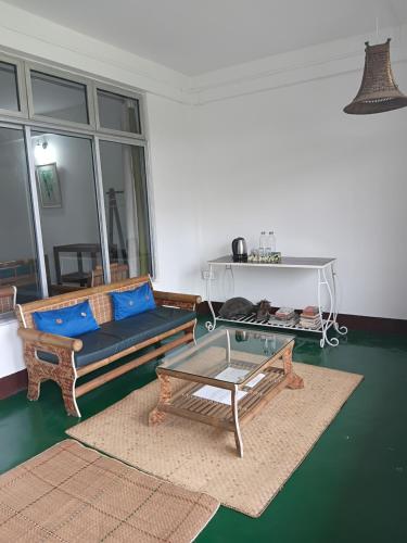 a living room with a couch and a table at Longchen Homestay in Dimapur