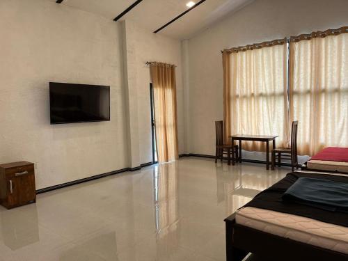 a room with a bed and a television on the wall at N4 Rest Hanthana in Etulgama
