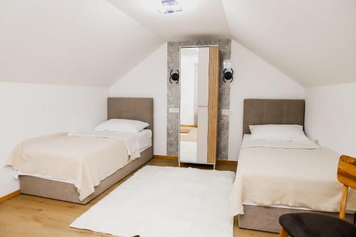 a bedroom with two beds and a mirror at Aurora in Ljubuški