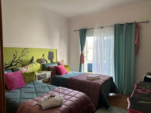a bedroom with two beds and a window at Marujo Home & Heart in Penedo Gordo