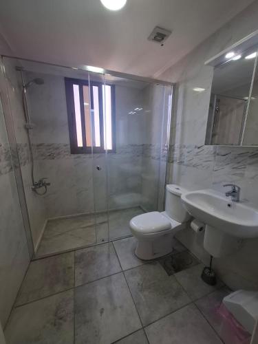 a bathroom with a toilet and a shower and a sink at Saint Paul Guesthouse in Zahlé