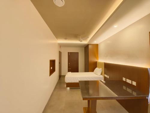 a bedroom with a bed and a desk in a room at Arthana Grand Inn in Udumalaippettai
