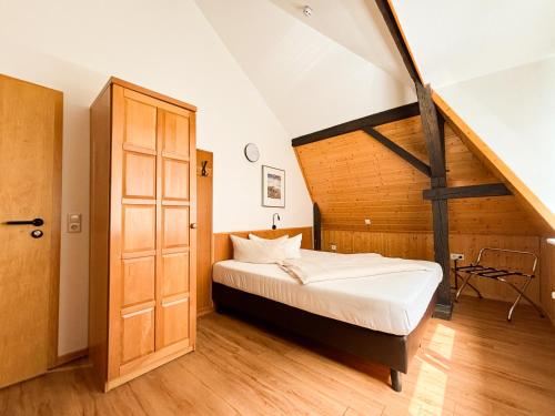 a bedroom with a bed and a wooden door at Hotel Schillerbad in Lüdenscheid