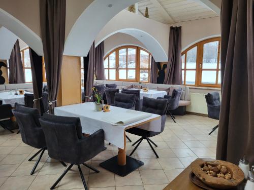 a restaurant with a white table and chairs at Landhaus Auhirsch in Böbrach