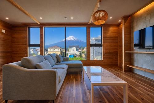 a living room with a couch and a view of a mountain at Miire Mt Fuji Forest in Fujikawaguchiko
