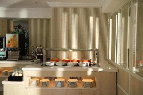 a kitchen with plates and bowls on a counter at Hotel Playa Mondrago in Portopetro