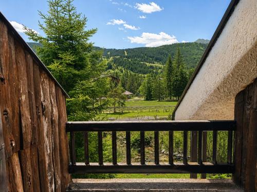 a wooden stairway with a view of a field at Hostdomus - Le Morette in Cesana Torinese