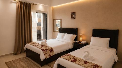 a hotel room with two beds and a window at Sol Pyramids Rooftop View Giza in Cairo