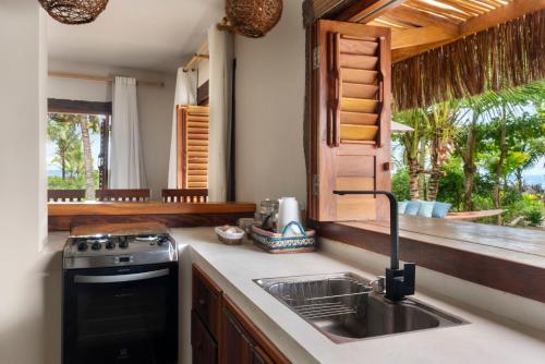 a kitchen with a sink and a stove and a window at Reserva Pratigi in Ituberá