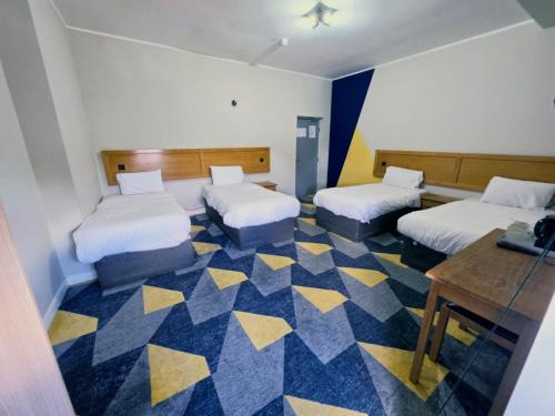 a hotel room with two beds and a desk at Dream Hotel in Manchester