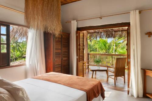 a bedroom with a bed and a balcony at Reserva Pratigi in Ituberá
