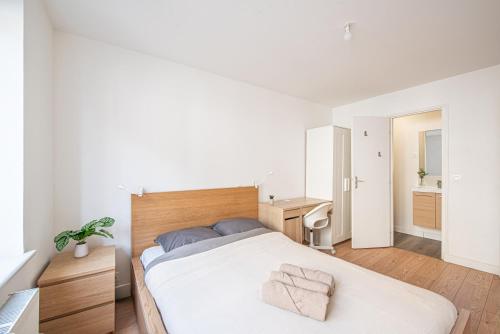 a white bedroom with a bed and a desk at Maison Cuvier - Spacieuse Maison Idéale Groupes & Pros in Roubaix