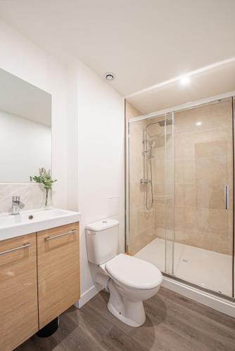 a white bathroom with a toilet and a shower at Maison Cuvier - Spacieuse Maison Idéale Groupes & Pros in Roubaix