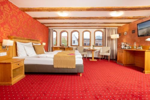 a hotel room with a large bed and a desk at Scheelehof - Ein Lieblingsplatz Hotel in Stralsund