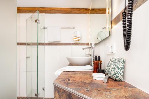 a bathroom with a sink and a shower at Scheelehof - Ein Lieblingsplatz Hotel in Stralsund