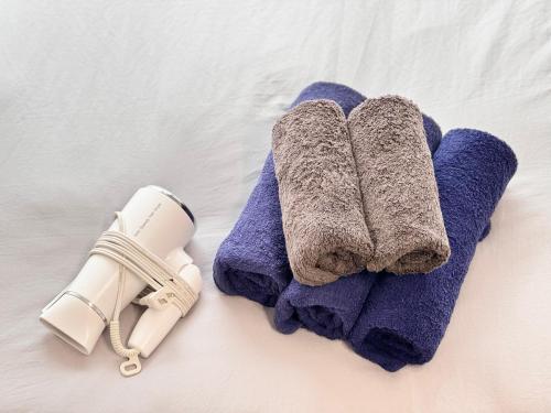 a pair of towels and a thermometer on a bed at ura 東横のヨコ301 in Kaigandōri