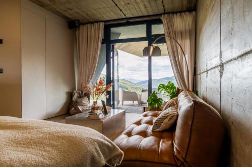 a bedroom with a couch and a large window at Słoneczny Stok in Międzybrodzie Żywieckie