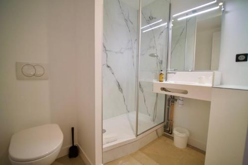 a bathroom with a shower and a toilet and a sink at Hotel Arcantis Le Voltaire in Rennes