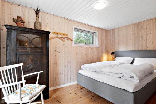 a bedroom with a bed and a chair and a window at OH593-Hadsund-Halvrebene-124 in Hadsund