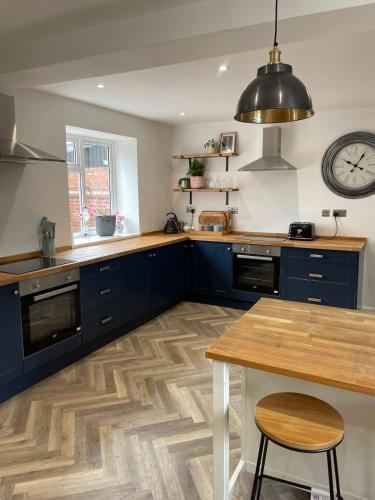 a kitchen with blue cabinets and a wooden floor at Deighton Lodge in York