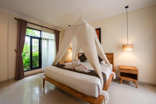 a bedroom with a bed with a mosquito net at Bali Ayu Hotel & Villas 10 Minutes Walking Distance to the Beach in Seminyak