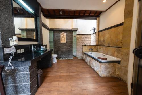 a large bathroom with a tub and a sink at Bali Ayu Hotel & Villas 10 Minutes Walking Distance to the Beach in Seminyak