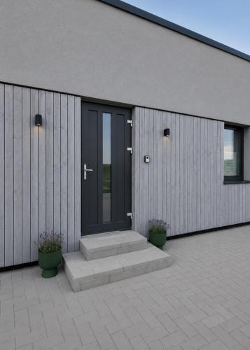 a building with two potted plants on a patio at Wake&wave in Užpelkiai