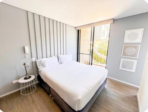 a bedroom with a large bed and a large window at Distrito Prime 1-302 in Bogotá