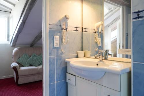 a bathroom with a sink and a mirror at Logis Hôtel Auberge Lukaïna in Urrugne