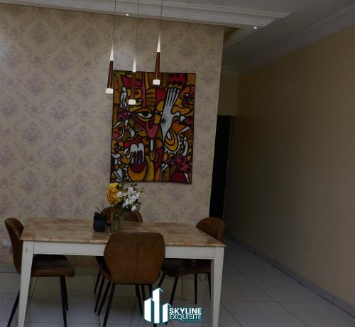 a dining room table with a painting on the wall at Skyline Exquisite in Araromi