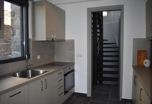 a kitchen with a sink and a staircase in the background at Μαυρόλιθος in Karistos