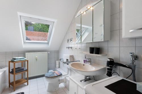 a white bathroom with a sink and a toilet at Fewo Krick in Bad Soden-Salmünster