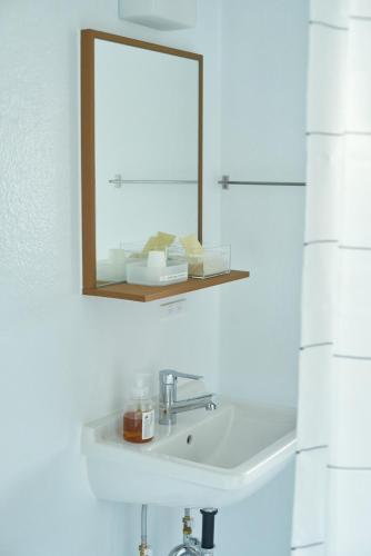 a bathroom with a sink and a mirror at SUISUI Hakushu Hotel in Shirasu