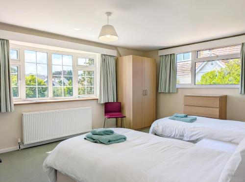 a bedroom with two beds and a purple chair at Still Waters, Emsworth in Emsworth