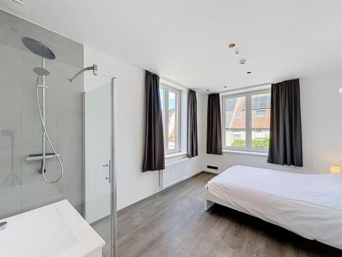 a white bedroom with a bed and a shower at Stellaross - Koksijde in Koksijde