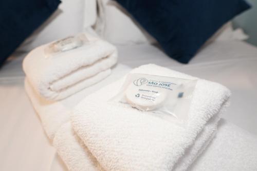a pile of towels sitting on top of a bed at Eventos e Hospedagem São José in Sorocaba