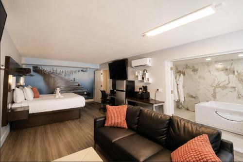 a living room with a couch and a bed at Envi Boutique Hotel Henderson-Evansville South in Henderson