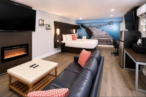 a hotel room with a couch and a bed and a staircase at Envi Boutique Hotel Henderson-Evansville South in Henderson