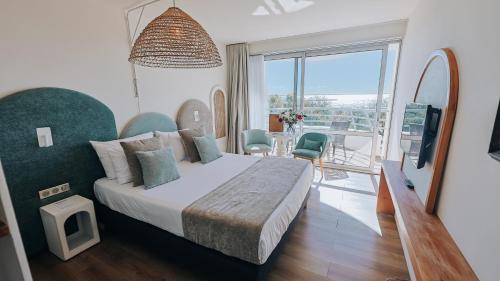 a hotel room with a bed and a balcony at Hôtel Les Corallines - Thalasso & Resort in La Grande Motte