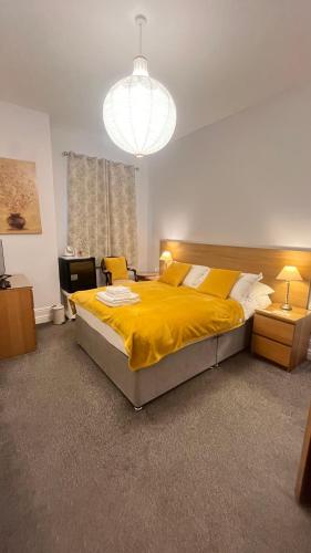 a bedroom with a large bed with a yellow blanket at The Beechwood in Leeds
