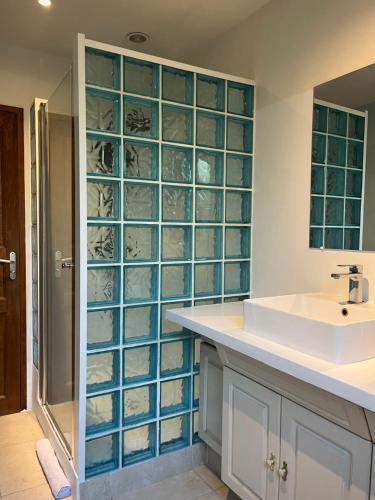 a bathroom with a sink and blue glass shelves at CASA Petra Rosa in Peri