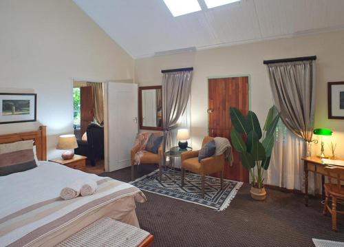 a bedroom with a bed and a living room at Great Dane at Brittlewood in Underberg
