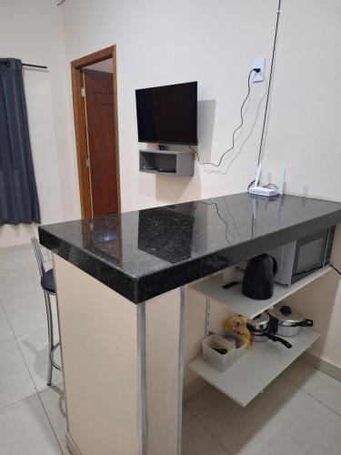 a black counter top in a room with a television at Apartamento Aconchegante 3 in Doutor Lund
